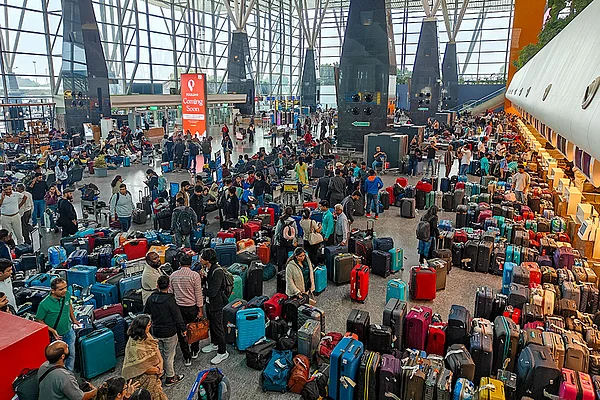 PTI/Shailendra Bhojak : Stranded passengers search for their luggage near a counter after IndiGo cancelled more than 400 flights, at the Kempegowda International Airport, in Bengaluru, Karnataka.