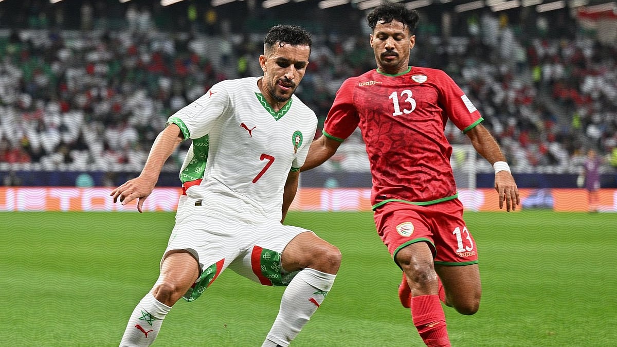 | Photo: X/EnMaroc : Comoros' Musab Al-Mamari challenges for the ball against Morocco's Mohamed Boulacsout during their FIFA Arab Cup match on December 5, 2025.