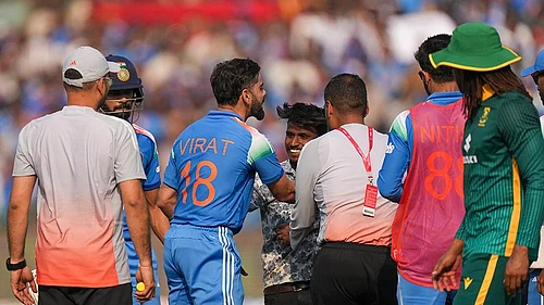 | Photo: PTI/Kunal Patil : Indias Virat Kohli, center, being greeted by a pitch invader between overs during the second ODI cricket match of a series between India and South Africa, at Shaheed Veer Narayan Singh International Stadium, in Raipur, Chhattisgarh.