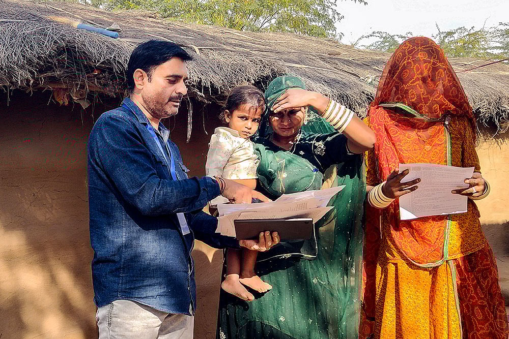 | Photo: PTI : A booth level officer (BLO) assists voters in filling out enumeration forms for the special intensive revision (SIR) of electoral rolls, in Bikaner, Rajasthan.