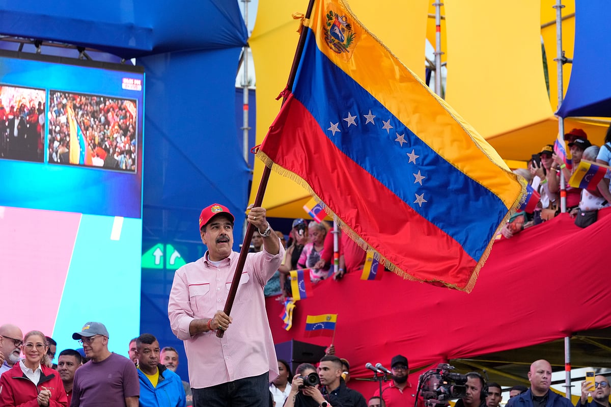 Ariana Cubillos : President Nicolas Maduro waves a Venezuelan flag during a swearing-in event for government-organized community committees at the presidential palace in Caracas, Venezuela, Monday, Dec. 1, 2025. 