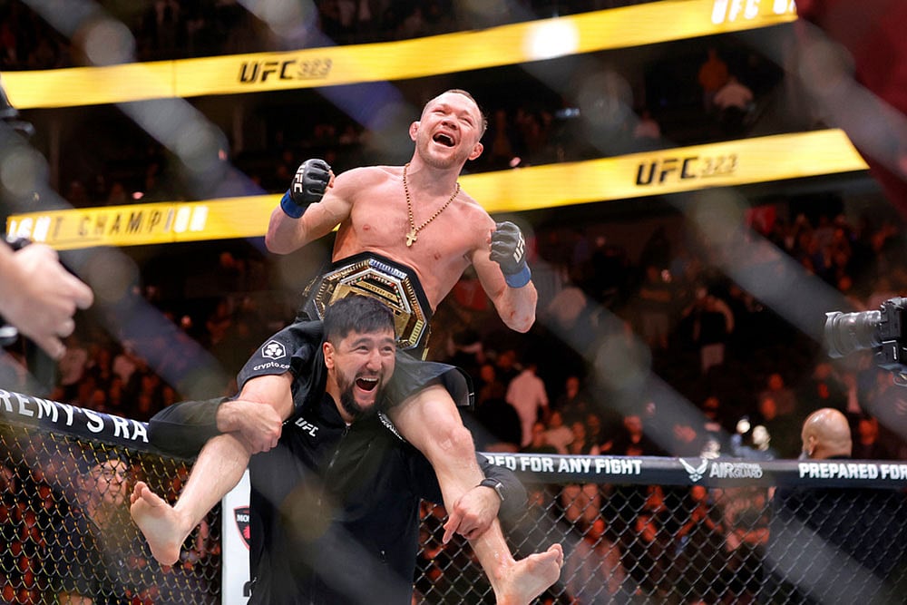 | Photo: Steve Marcus/Las Vegas Sun via AP : Petr Yan celebrates with a member of his team after defeating UFC bantamweight champion Merab Dvalishvili during UFC 323 in Las Vegas.