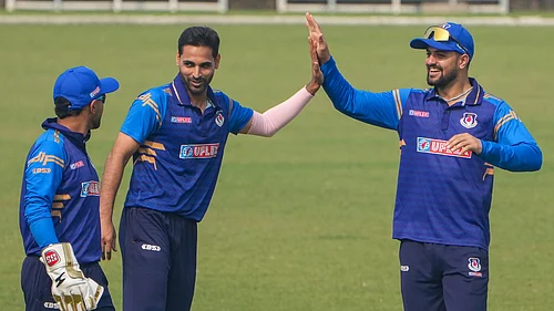 PTI : Uttar Pradeshs Bhuvneshwar Kumar, centre, celebrates with his teammates after taking the wicket.