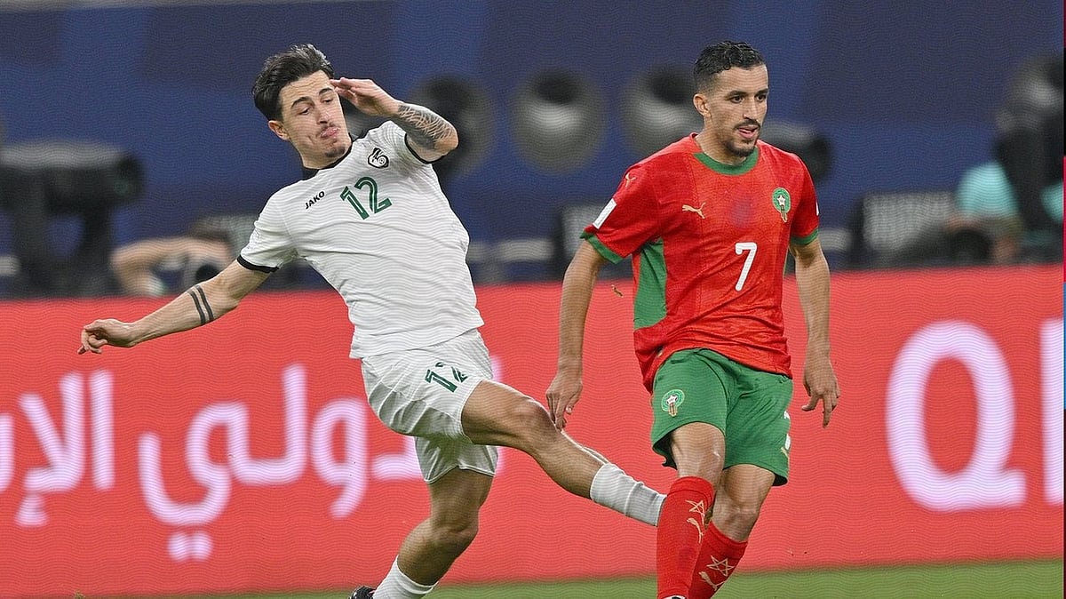 | Photo: X/EnMaroc : Syria's Antonio Yakoub challenges for the ball against Morocco's Mohamed Boualcsout during their FIFA Arab Cup match on December 11, 2025.