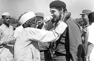 India Cuba: An elderly villager and member of indian communist party garlanding Che Guevara during his visit to a Community Project Area in Delhi, 1959