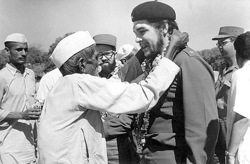 India Cuba: An elderly villager and member of indian communist party garlanding Che Guevara during his visit to a Community Project Area in Delhi, 1959