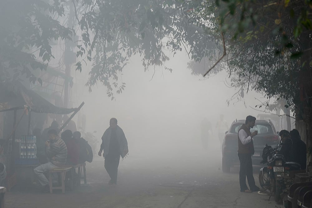 | Photo: AP/Shahbaz Khan : People have tea at a roadside stall during a cold and smoggy winter morning, in New Delhi. Delhi battled toxic fumes on Sunday as the air quality slipped into the severe category with a reading of 459, according to the Central Pollution Control Board. 
