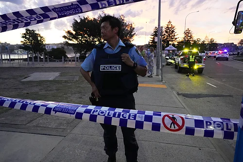 | Photo: AP/Mark Baker : Police cordon off an area at Bondi Beach after a reported shooting in Sydney.