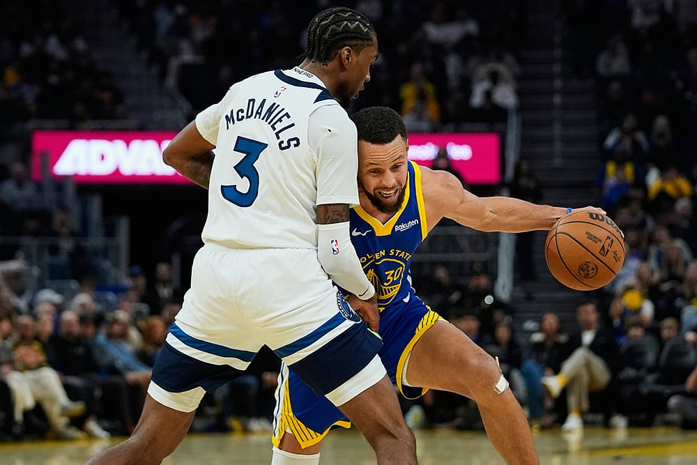 | Photo: AP/Godofredo A. Vásquez : Golden State Warriors guard Stephen Curry, right, moves the ball while defended by Minnesota Timberwolves forward Jaden McDaniels during the first half of an NBA basketball game in San Francisco. 