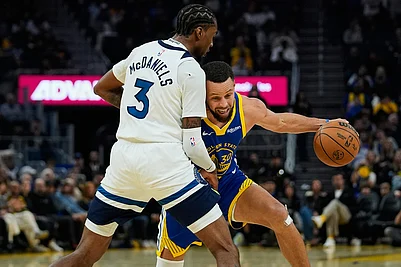 | Photo: AP/Godofredo A. Vásquez : Golden State Warriors guard Stephen Curry, right, moves the ball while defended by Minnesota Timberwolves forward Jaden McDaniels during the first half of an NBA basketball game in San Francisco.