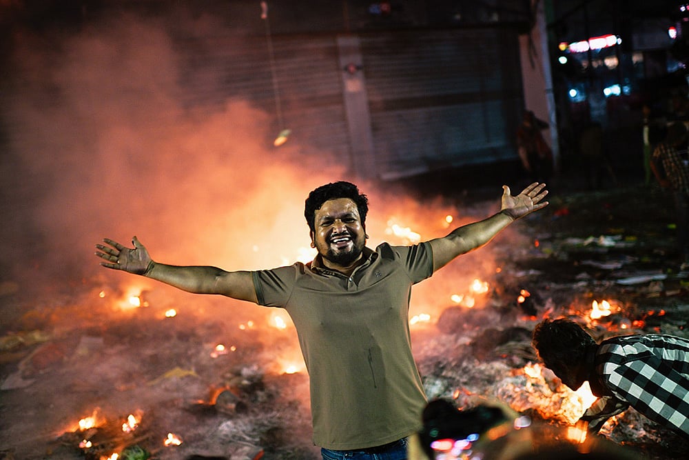 | Photo: AP/Mahmud Hossain Opu : A protester reacts to the camera near the premises of the Prothom Alo daily newspaper which was set on fire by angry protesters after news reached the country from Singapore of the death of a prominent activist Sharif Osman Hadi, in Dhaka, Bangladesh.