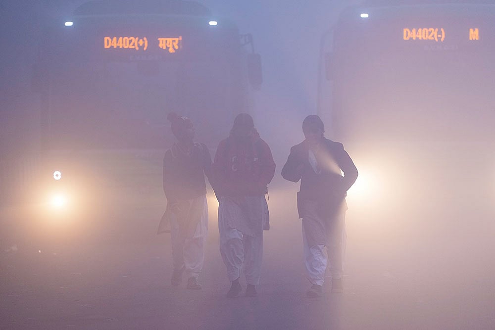 | Photo: PTI/Ravi Choudhary : School children brave dense fog on a winter morning, at Mayur Vihar area, in New Delhi. Visibility plunged across parts of Delhi on Saturday morning, with buildings and flyovers fading into a grey blur amid dense fog, as the capital’s AQI edged closer to the ‘severe’  category at 384.