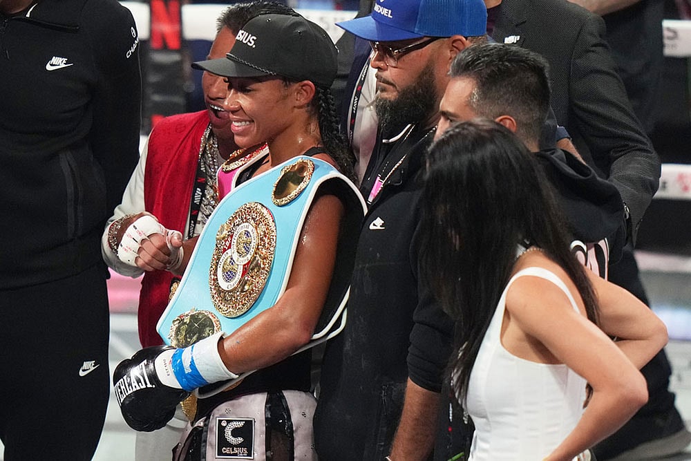 | Photo: AP/Lynne Sladky : Alycia Baumgardner, left, poses with her belt after her during super-featherweight fight against Lela Beaudoin in Miami.