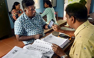 PTI : A Booth Level Officer (BLO) interacts with a voter as he checks and collects filled enumeration forms for the special intensive revision (SIR) of electoral rolls, in Thiruvananthapuram,