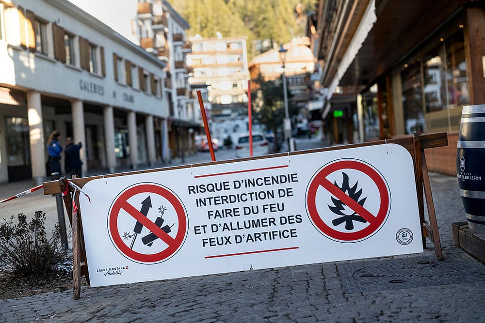 Photo: Alessandro della Valle/Keystone via AP : A banner stating that fireworks are prohibited due to the risk of fire is pictured near the area where a fire broke out  at the Le Constellation bar and lounge leaving people dead and injured, during New Year’s celebration, in Crans-Montana, Swiss Alps, Switzerland.