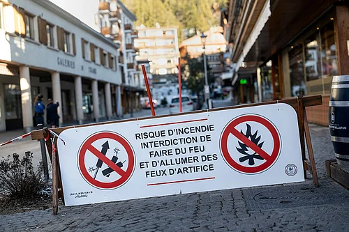 Photo: Alessandro della Valle/Keystone via AP : A banner stating that fireworks are prohibited due to the risk of fire is pictured near the area where a fire broke out at the Le Constellation bar and lounge leaving people dead and injured, during New Year’s celebration, in Crans-Montana, Swiss Alps, Switzerland.
