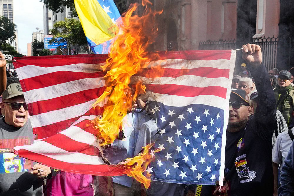 Photo: AP/Ariana Cubillos : Government supporters burn a U.S. flag in Caracas, Venezuela, after U.S. President Donald Trump announced that U.S. forces had captured Venezuelan President Nicolás Maduro and his wife. 