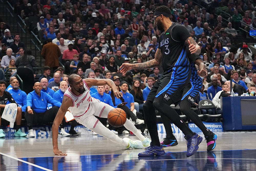 | Photo: AP/Julio Cortez : Houston Rockets forward Kevin Durant, left, falls to the floor while attacking against Dallas Mavericks forward Anthony Davis (3) and a teammate during the first half of an NBA basketball game in Dallas.