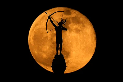 | Photo: AP/Charlie Riedel : The full moon rises behind the statue, Ad Astra, atop the Kansas Statehouse in Topeka, Kan.