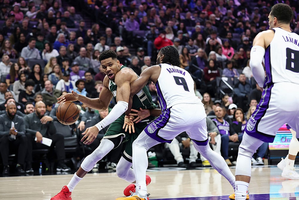 | Photo: AP/Sara Nevis : Milwaukee Bucks forward Giannis Antetokounmpo, left, drives to the basket with Sacramento Kings forward Precious Achiuwa (9) defending during the first half of an NBA basketball game in Sacramento, California. 