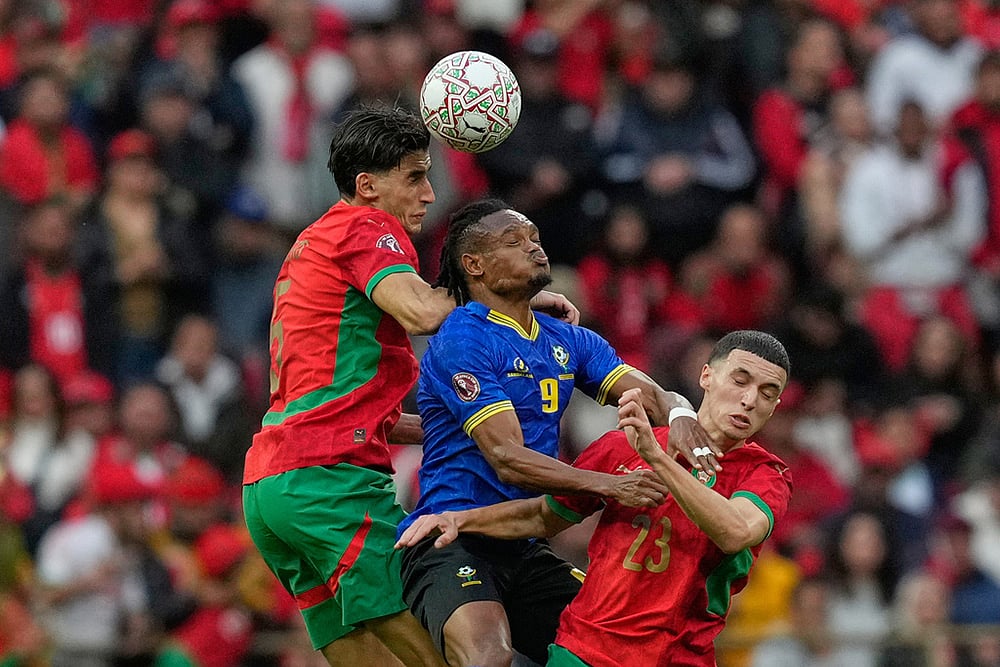 | Photo: AP/Mosaab Elshamy : Tanzanias Selamani Mwalimu, center, fights for the ball with Moroccos Nayef Aguerd, left and Bilal El Khannouss during the Africa Cup of Nations round of 16 soccer match between Morocco and Tanzania in Rabat, Morocco.