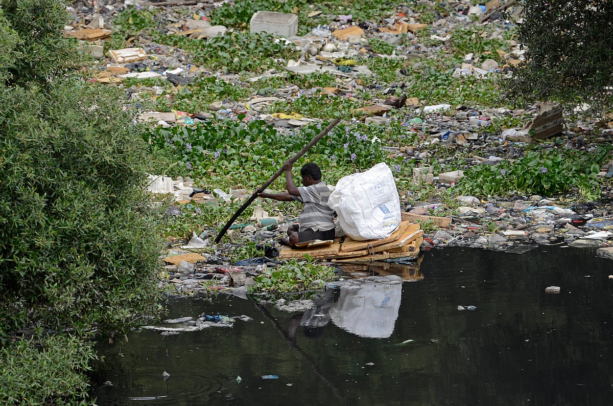 IMAGO / NurPhoto : A man paddles a makeshift raft made of thermocol sheets through the polluted waters of the Mithi River in Mumbai, India, on July 1, 2025. The river, which flows through the city s industrial and residential zones, remains heavily contaminated due to untreated sewage and solid waste dumping, posing serious health and environmental risks.