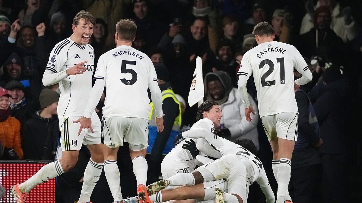 (AP Photo/Dave Shopland) : Fulhams Raul Jimenez, bottom covered, celebrates with teammates after scoring the opening goal during the English Premier League soccer match between Fulham and Chelsea in London, Wednesday, Jan. 7, 2026.