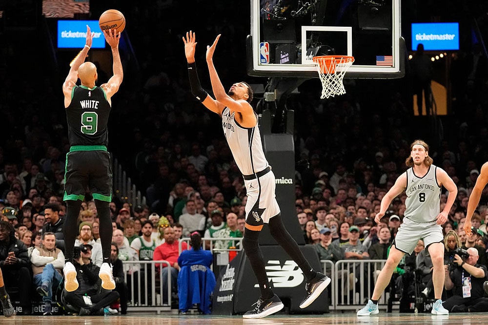 | Photo: AP/Robert F. Bukaty : Boston Celtics guard Derrick White (9) shoots over San Antonio Spurs forward Victor Wembanyama during the second half of an NBA basketball game in Boston.