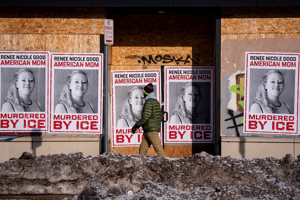Christopher Katsarov : A person walks past signage for Renee Good, who was fatally shot by an ICE officer earlier in the week, in Minneapolis, Minn., Sunday, Jan. 11, 2026. 