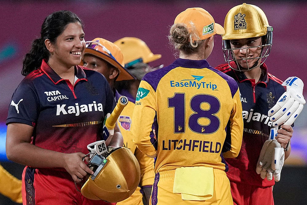 | Photo: PTI/Kunal Patil : Royal Challengers Bengalurus captain Smriti Mandhana, right, and Richa Ghosh, left, being congratulated by UP Warriorzs Phoebe Litchfield after winning the Womens Premier League (WPL) T20 cricket match between Royal Challengers Bengaluru and UP Warriorz, at the DY Patil Stadium in Navi Mumbai.