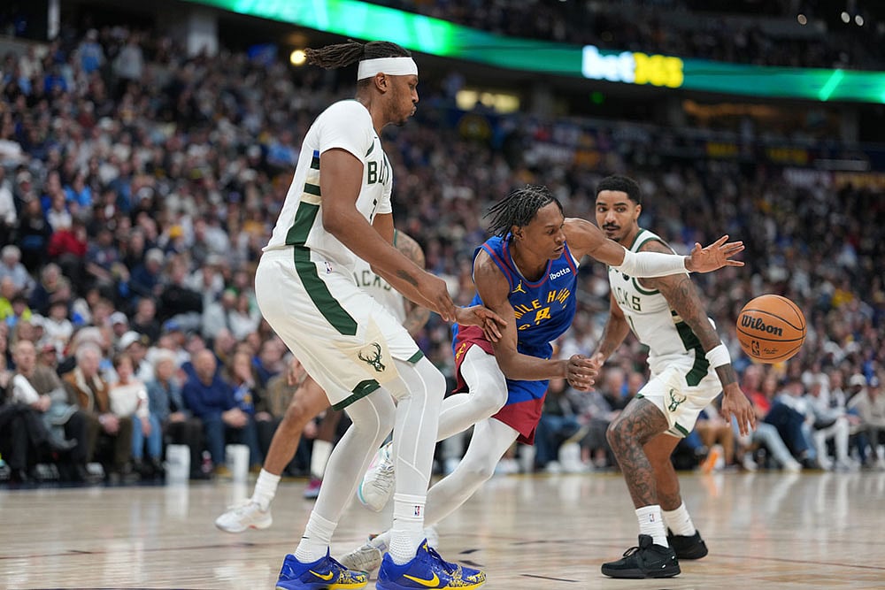 | Photo: AP/David Zalubowski : Denver Nuggets guard Peyton Watson, center, loses control of the ball while driving between Milwaukee Bucks center Myles Turner, front, and guard Gary Harris in the second half of an NBA basketball game in Denver.