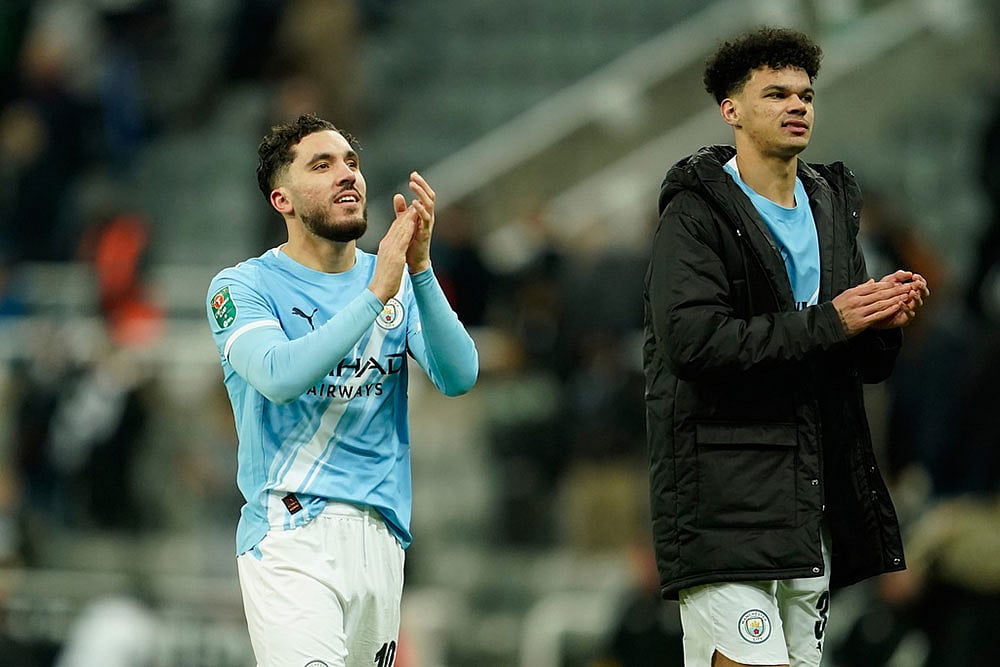 Photo: AP/Dave Thompson : Manchester Citys Rayan Cherki, left, and Manchester Citys Nico OReilly applaud fans at the end of the English League Cup semifinal first leg soccer match between Newcastle and Manchester City in Newcastle, England.