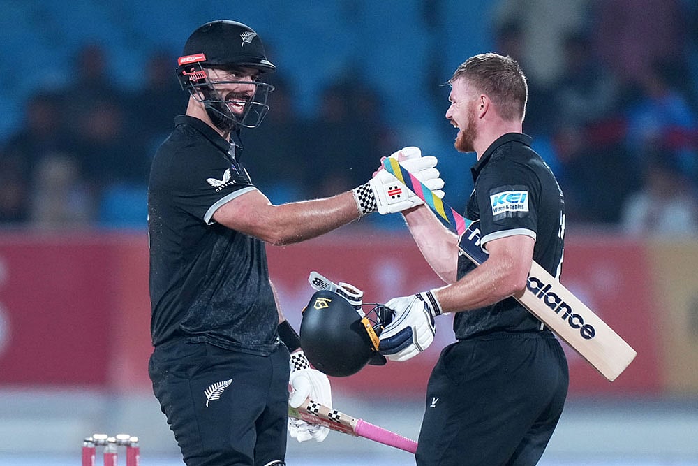 Photo: AP/Ajit Solanki : New Zealands Daryl Mitchell, left, and New Zealands Glenn Phillips celebrate their win during the second One Day International cricket match between India and New Zealand in Rajkot, India.