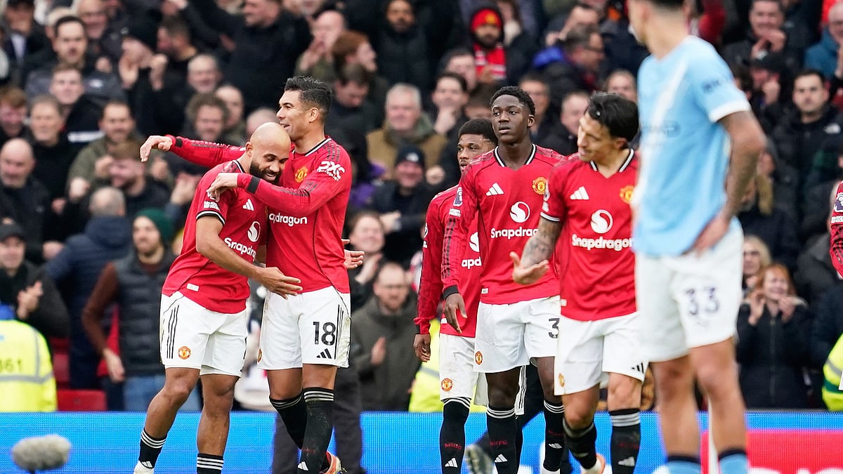 (AP Photo/Dave Thompson) : Manchester United's Bryan Mbeumo, left, celebrates after scoring his side's opening goal during the English Premier League soccer match between Manchester United and Manchester City in Manchester, England, Saturday, Jan. 17, 2026.