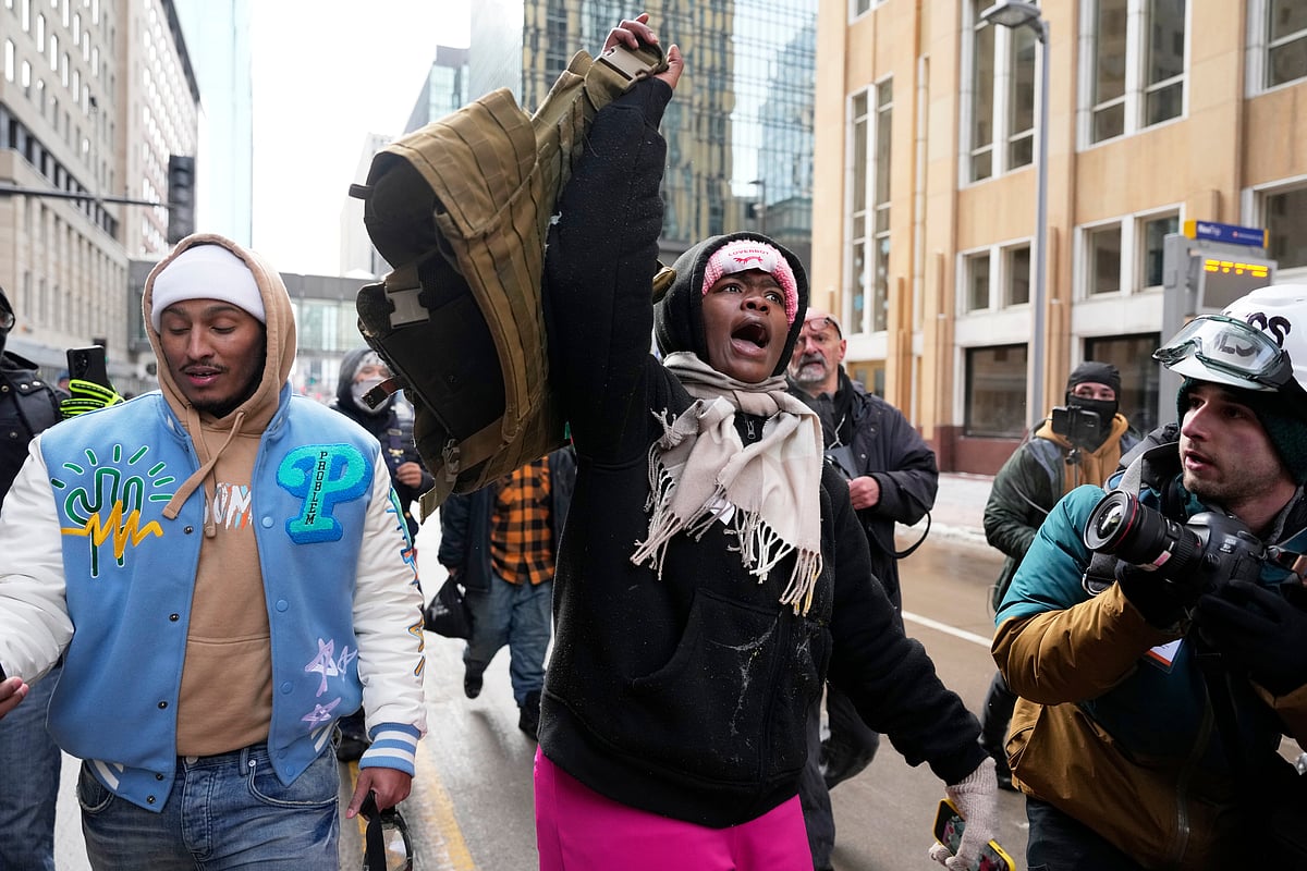 (AP Photo/Yuki Iwamura) : A pro-immigration protester lifts up Jake Langs vest after an altercation at the March Against Minnesota Fraud rally near Minneapolis City Hall, Saturday, Jan. 17, 2026, in Minneapolis. 