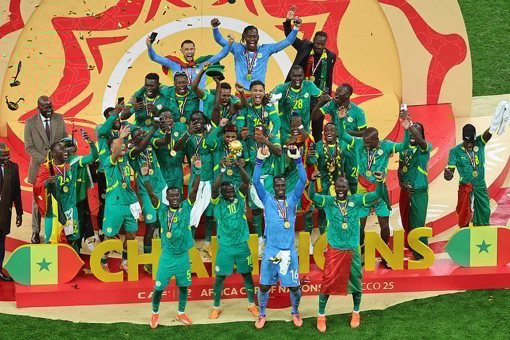 | Photo: AP/Youssef Loulidi : Senegals Sadio Mane holds the trophy aloft as he celebrates with teammates after winning the Africa Cup of Nations final soccer match between Senegal and Morocco in Rabat, Morocco.