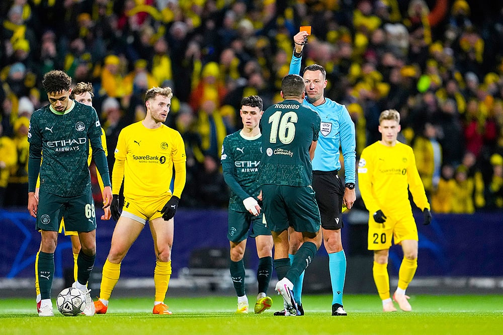 | Photo: Fredrik Varfjell/NTB via AP : Manchester Citys Rodri is shown a red card by referee Sven Jablonski during the Champions League soccer match between Bodo/Glimt and Manchester City in Bodo, Norway.