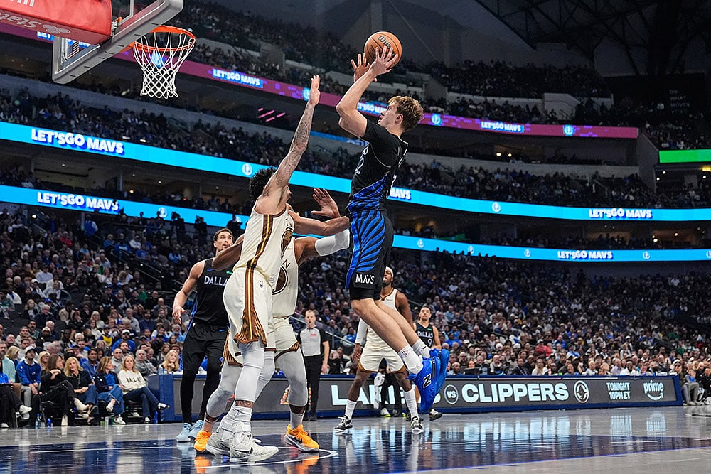 | Photo: AP/Tony Gutierrez : Dallas Mavericks forward Cooper Flagg shoots over Golden State Warriors Gui Santos, left, in the second half of an NBA basketball game in Dallas.