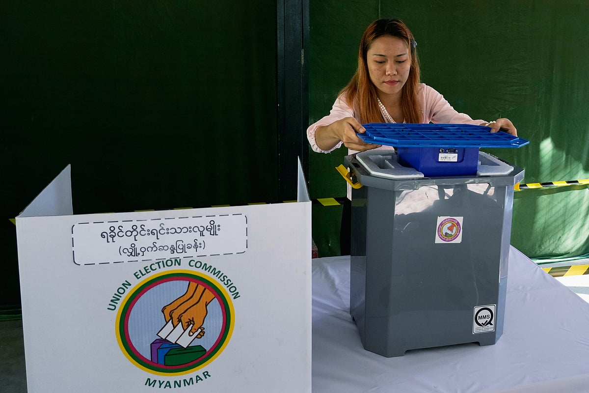 (AP Photo/Thein Zaw) : A official of the Union Election Commission prepares a voting booth at a polling station, one day ahead of the third phase of the general election, in Yangon, Myanmar, Saturday, Jan. 24, 2026. 