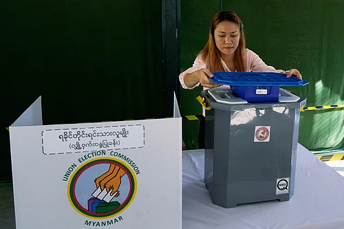 (AP Photo/Thein Zaw) : A official of the Union Election Commission prepares a voting booth at a polling station, one day ahead of the third phase of the general election, in Yangon, Myanmar, Saturday, Jan. 24, 2026.