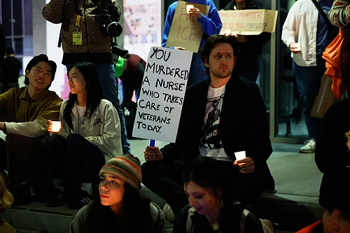 (AP Photo/Caroline Brehman) : Demonstrator holds a sign during a candlelight vigil during a protest in response to the fatal shooting of 37-year-old Alex Pretti in Minneapolis earlier in the day Saturday, Jan. 24, 2026, in Los Angeles.