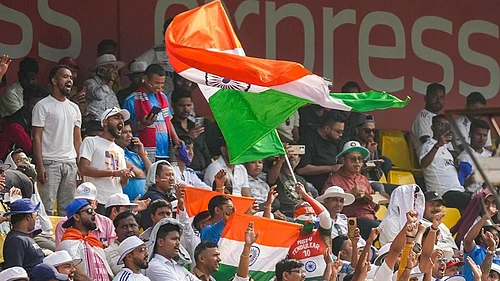 Photo: PTI/Shahbaz Khan : Fans wave the national flag during the day two of the second Test cricket match of a series between India and South Africa, at ACA Stadium in Guwahati.