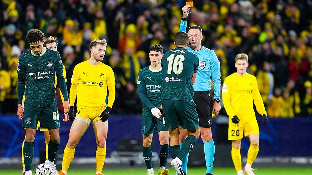 | Photo: Fredrik Varfjell/NTB via AP : Manchester City's Rodri is shown a red card by referee Sven Jablonski during the Champions League soccer match between Bodo/Glimt and Manchester City in Bodo, Norway.