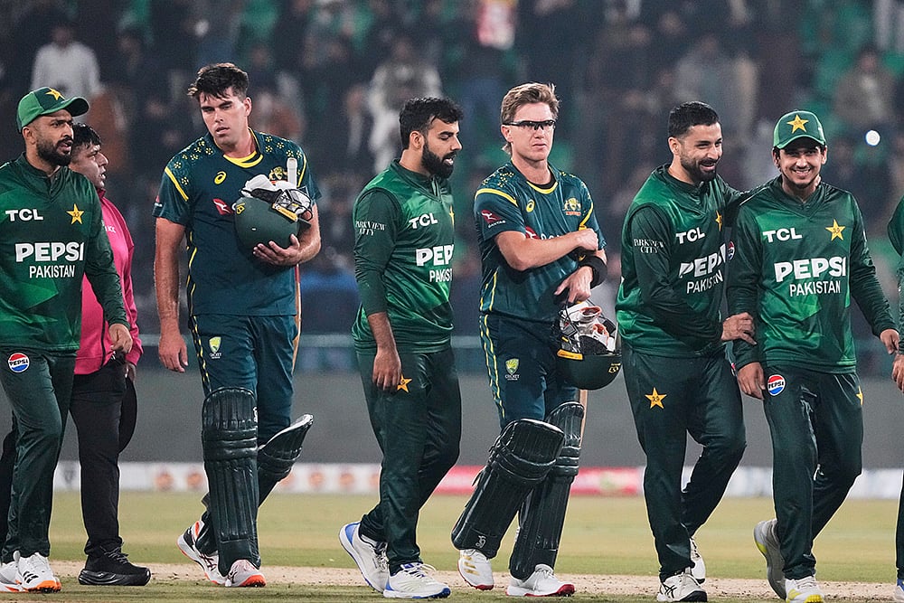 | Photo: AP/K.M. Chaudary : Australias Xavier Bartlett, second left, and Adam Zampa, third right, and Pakistani players walk off the field on the end of the first T20 cricket match between Pakistan and Australia, in Lahore, Pakistan.