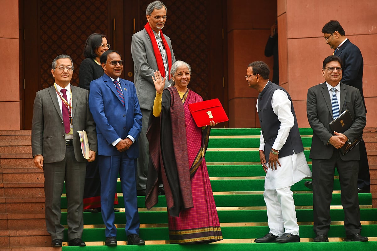 | Photo: AP : Indian Finance Minister Nirmala Sitharaman, center, displays a red folder containing the Union Budget 2026-27 at the steps of the parliament house before tabling it, in New Delhi, India, Sunday, Feb. 1, 2026.