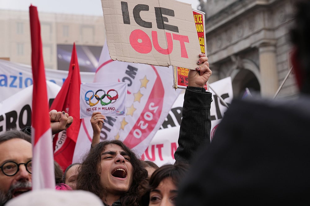 | Photo: AP/Antonio Calanni : A person holds a sign, during an Anti-ICE demonstration, ahead of the 2026 Winter Olympics, in Milan, Italy.