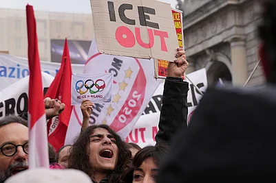 | Photo: AP/Antonio Calanni : A person holds a sign, during an Anti-ICE demonstration, ahead of the 2026 Winter Olympics, in Milan, Italy.