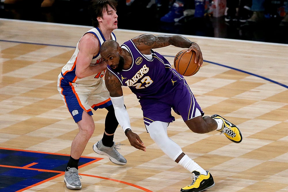 | Photo: AP/John Munson : Los Angeles Lakers forward LeBron James (23) dribbles around New York Knicks guard Tyler Kolek, left, during the first half of an NBA basketball game in New York. 