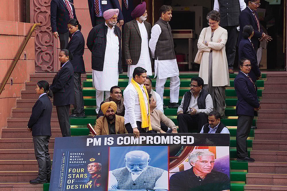 | Photo: PTI/Salman Ali : Congress MP Priyanka Gandhi Vadra with Lok Sabha MPs who were suspended on Tuesday for the remainder of the Budget session for unruly behaviour, as they stage a protest with a poster ‘PM is compromised’, at Parliament premises in New Delhi.