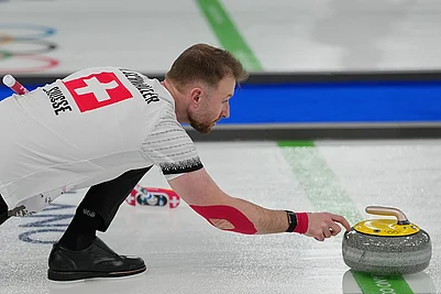 | Photo: AP/Misper Apawu : Switzerlands Yannick Schwaller competes during the mixed doubles round robin phase of the curling competition against Estonia at the 2026 Winter Olympics, in Cortina dAmpezzo, Italy.